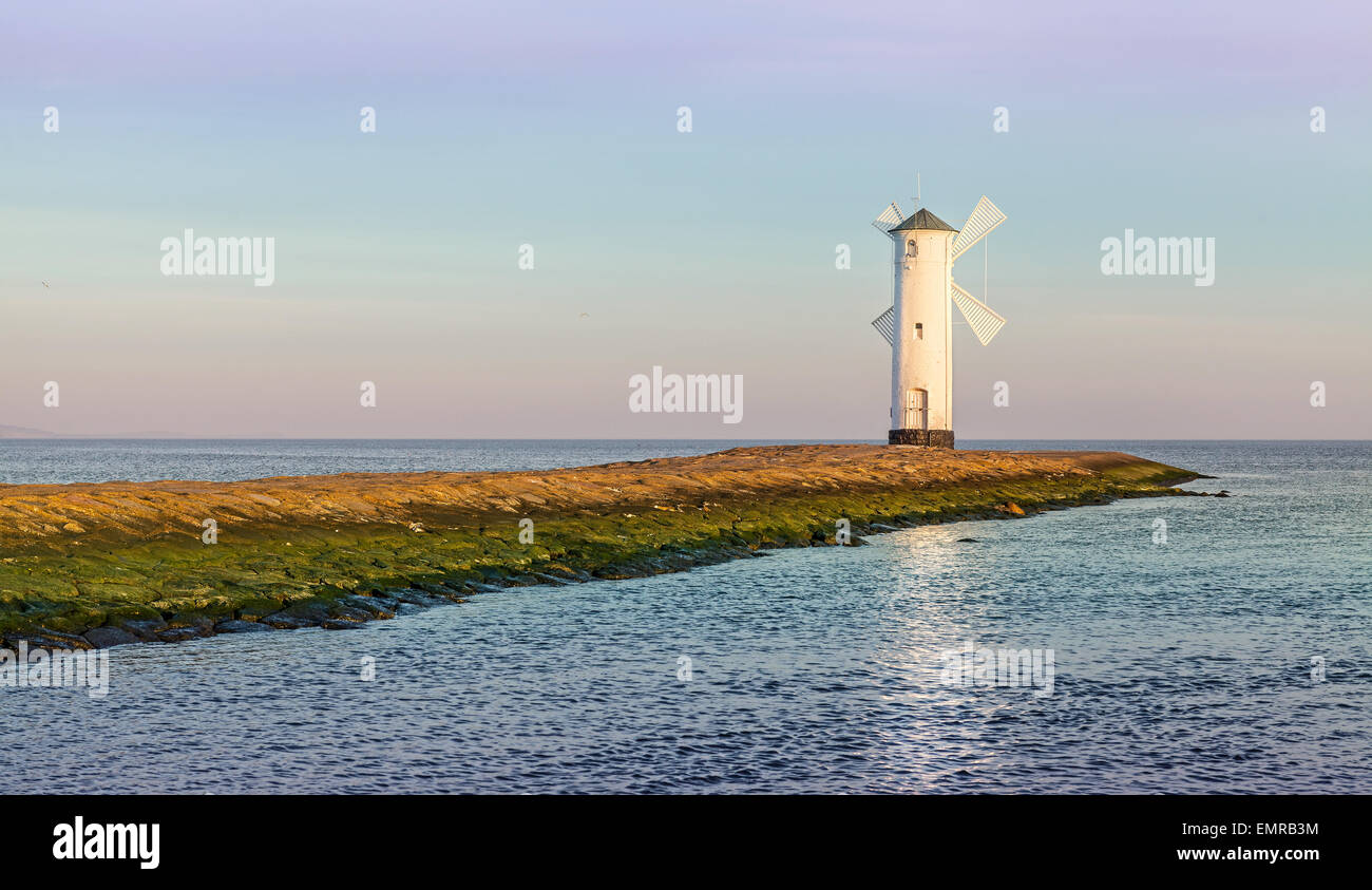 Amanecer en la costa del Mar Báltico, el faro en Swinoujscie, Polonia. Foto de stock