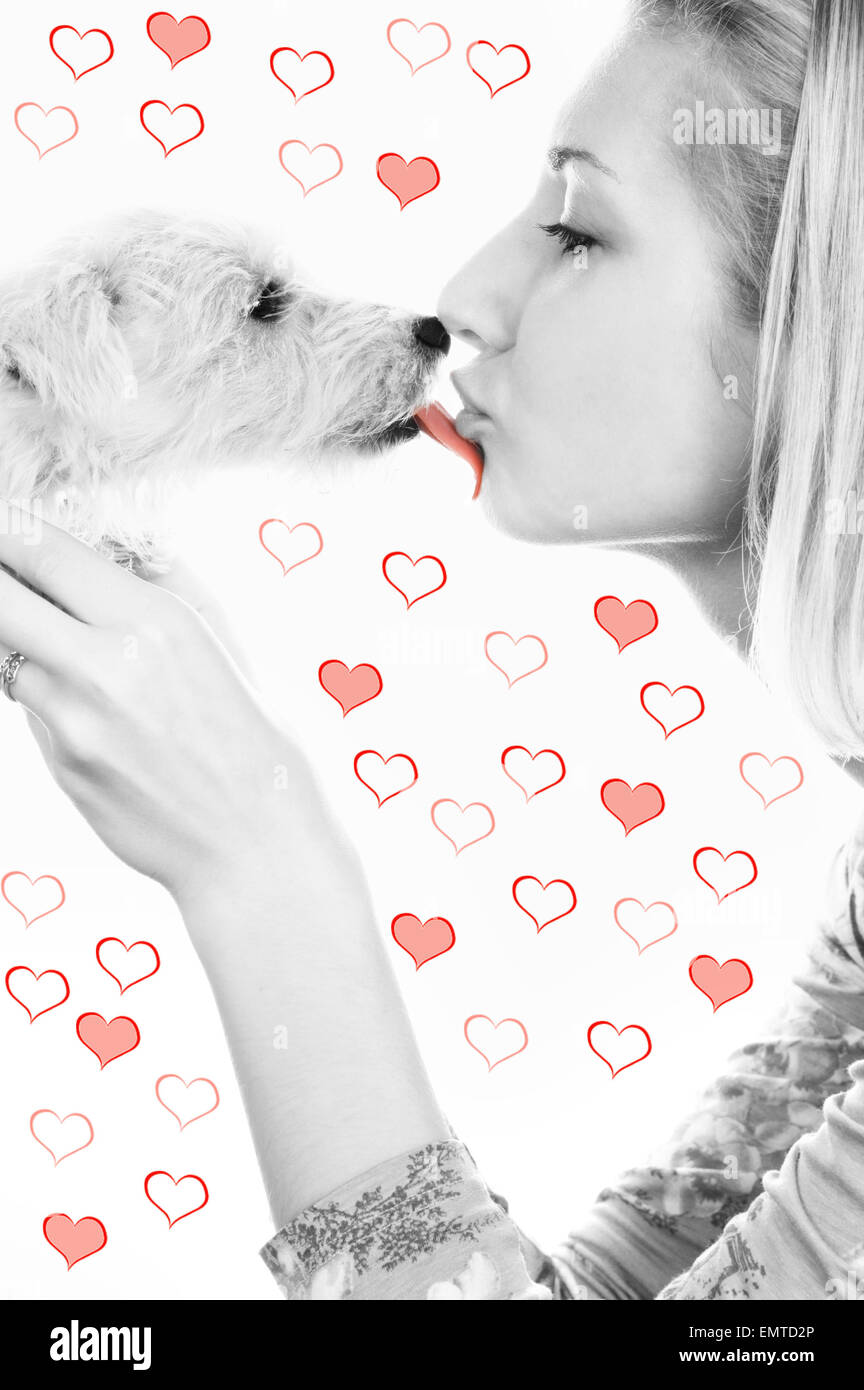 Chica rubia con un dulce cachorro en abstracto de fondo del corazón Foto de stock