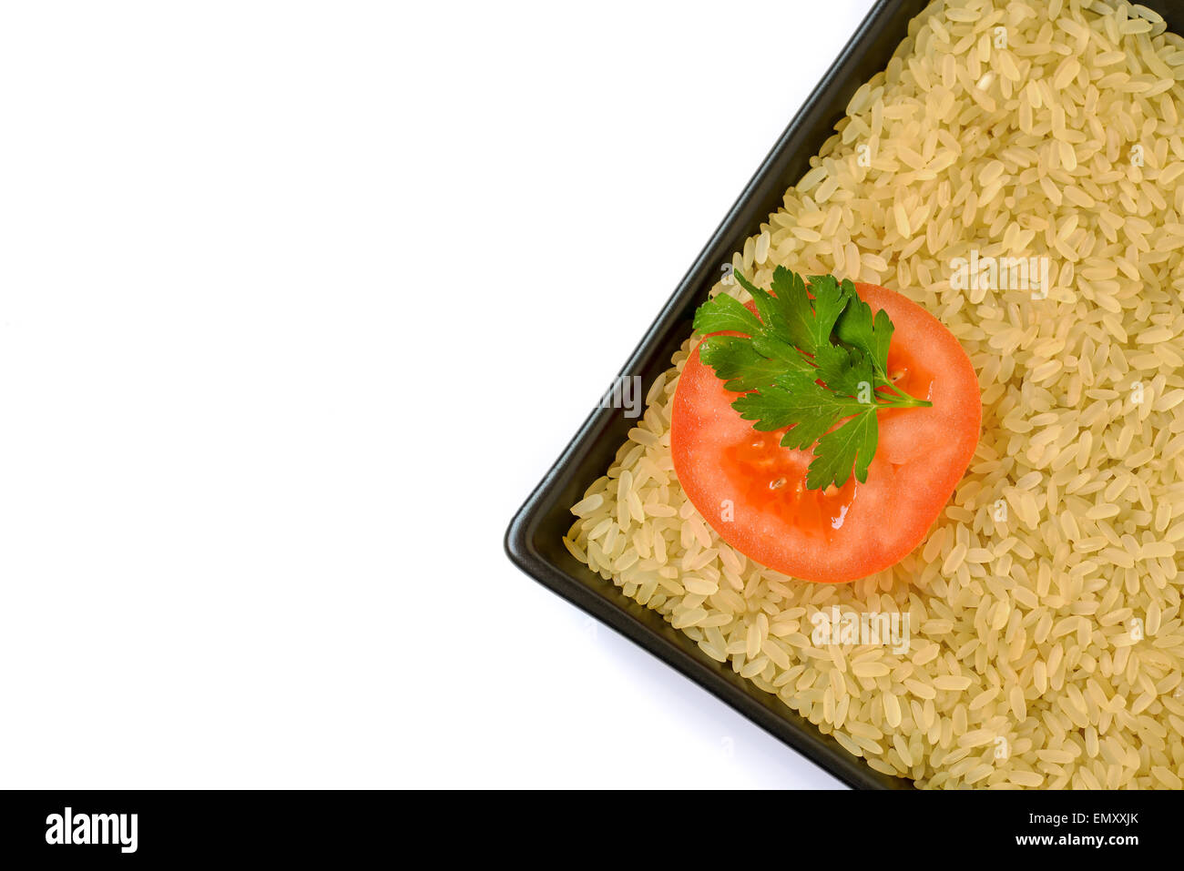 Placa con arroz crudo y la rodaja de tomate Foto de stock