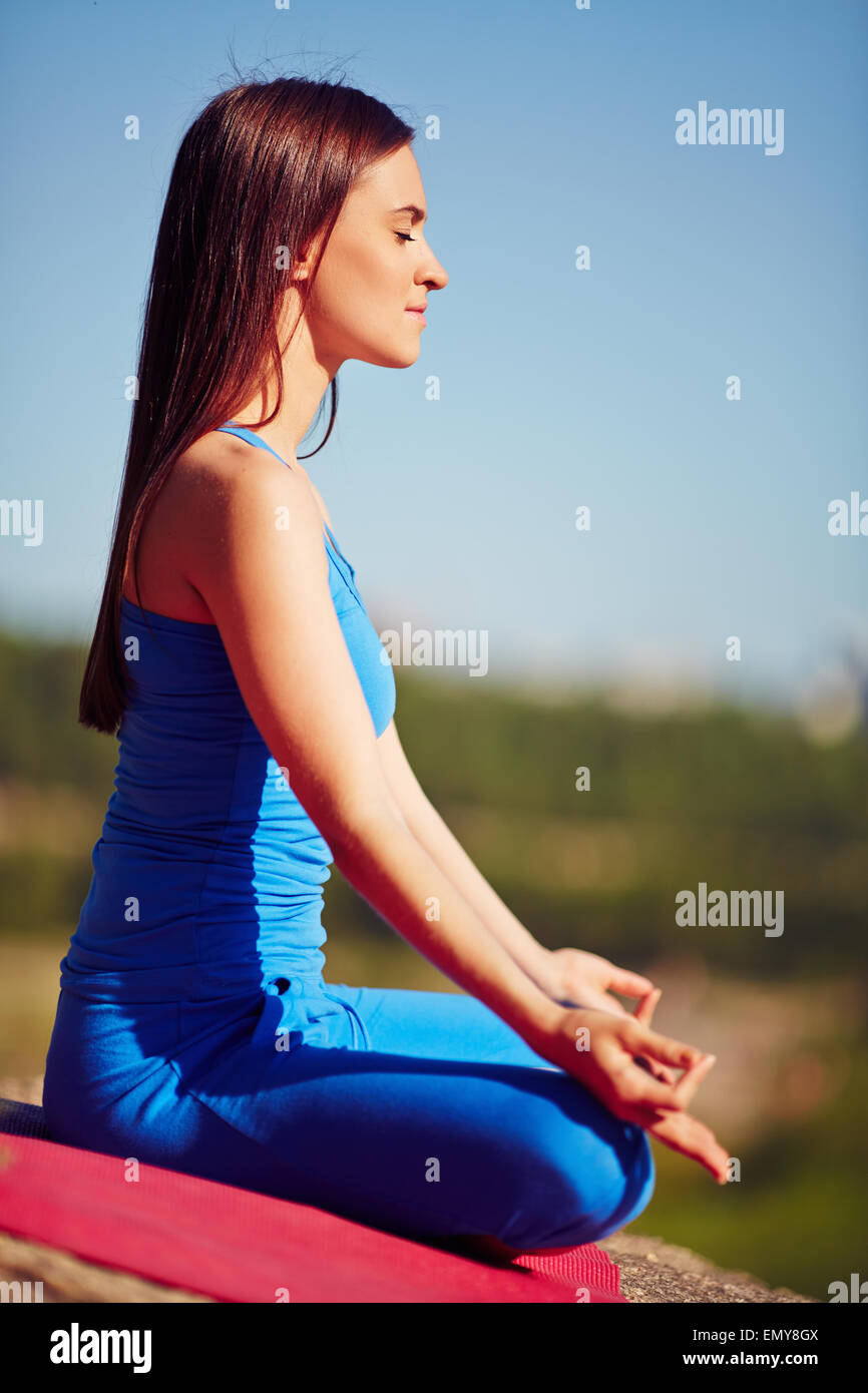 Mujer meditando en pose relajada de Lotus en el exterior Foto de stock
