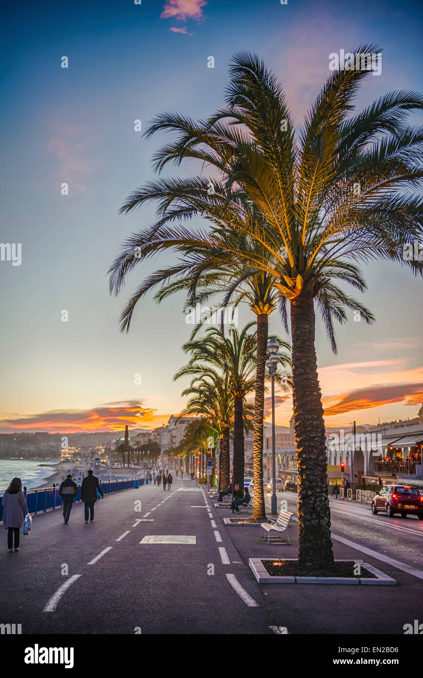 La gente caminando a lo largo de la Promenade des Anglais en Niza al atardecer Foto de stock