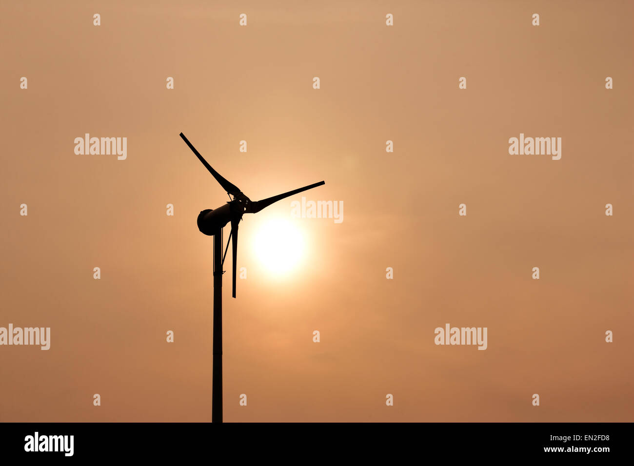 Turbina de viento en contra de una puesta de sol. Foto de stock