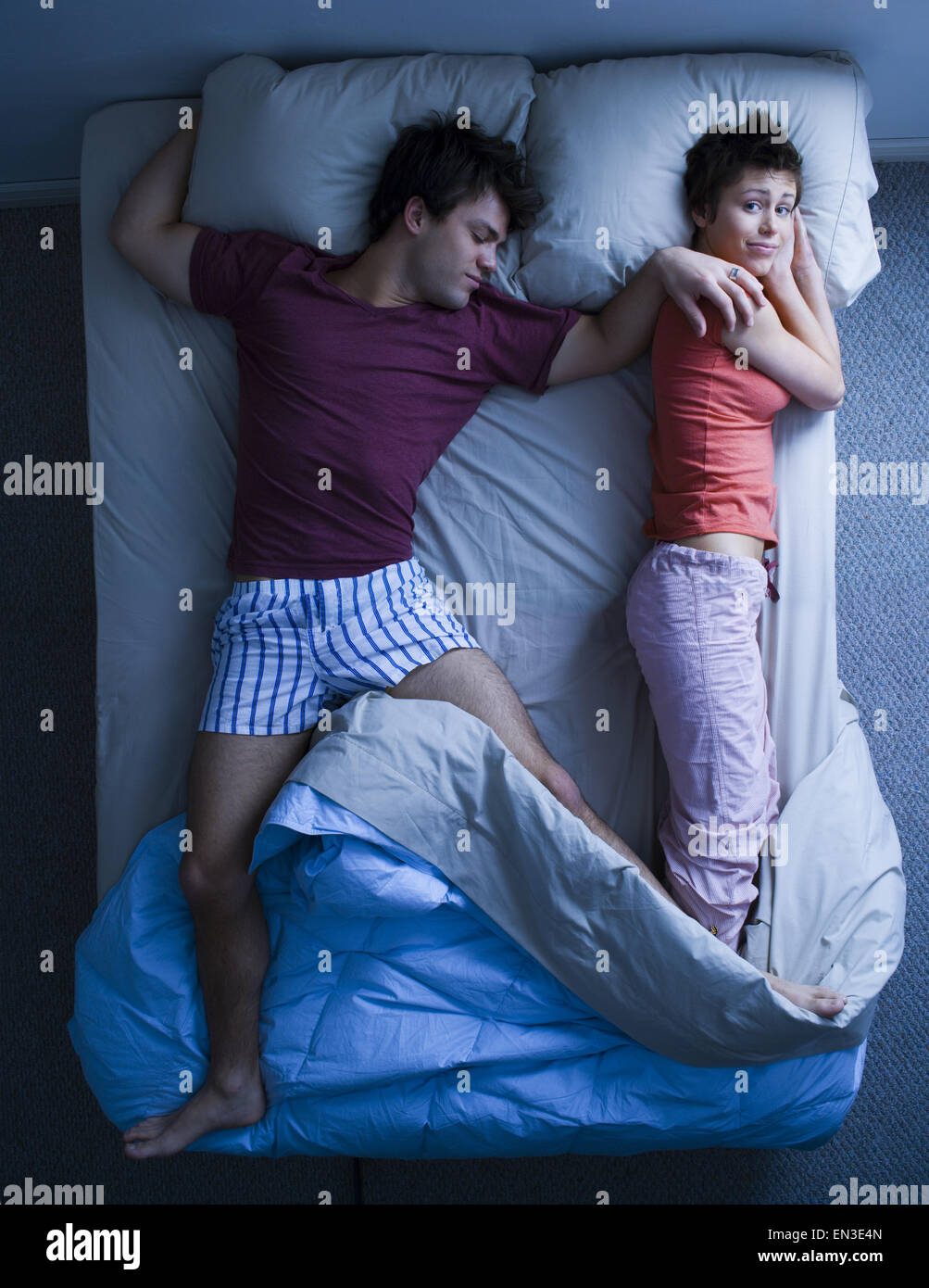 El hombre tumbado en la cama con una mujer durmiendo Foto de stock