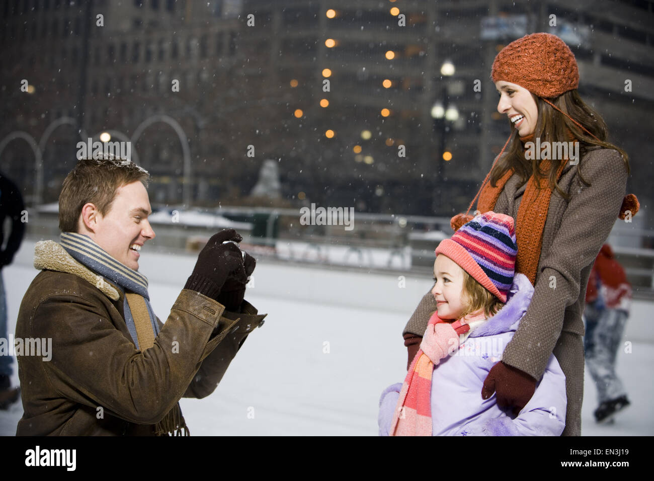 Hombre tomar la foto de la mujer y la niña en el exterior en invierno Foto de stock