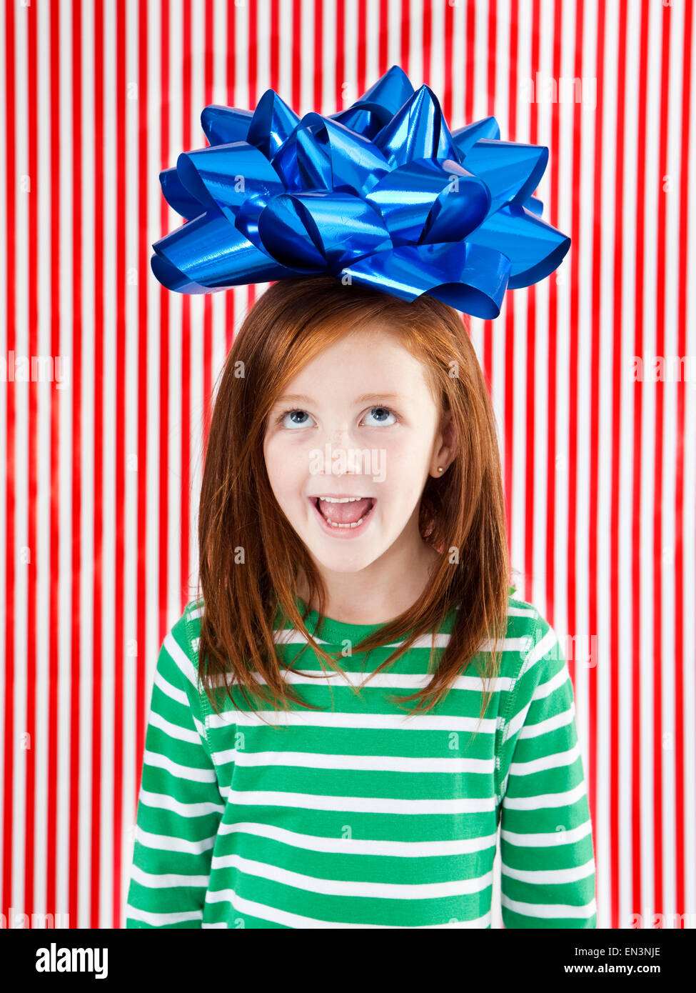 Foto de estudio de chica (4-5) con un gran arco de regalo en la cabeza. Foto de stock