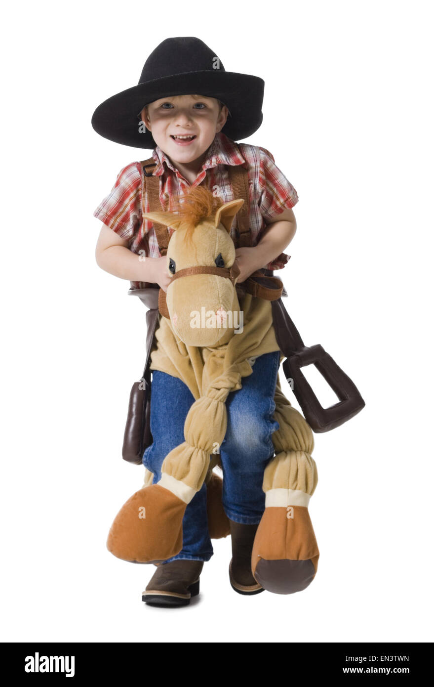 Niño con rifle de juguete y caballo con sombrero de vaquero Foto de stock