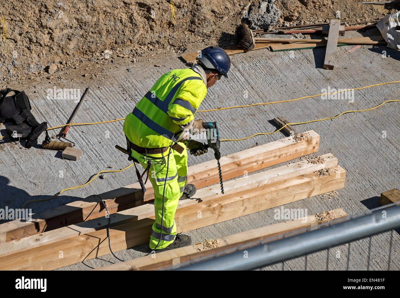 Un trabajador de la construcción con un gran taladro eléctrico Foto de stock