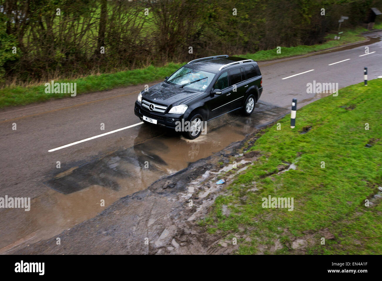 Un 4X4, conducción sobre baches inundadas en las zonas rurales de Inglaterra Foto de stock