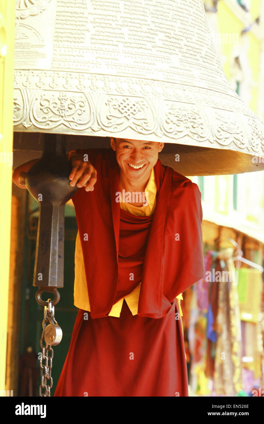 Feliz sonriente monje bajo campana ceremoniales. Katmandú, Nepal.templo boudhanath Foto de stock