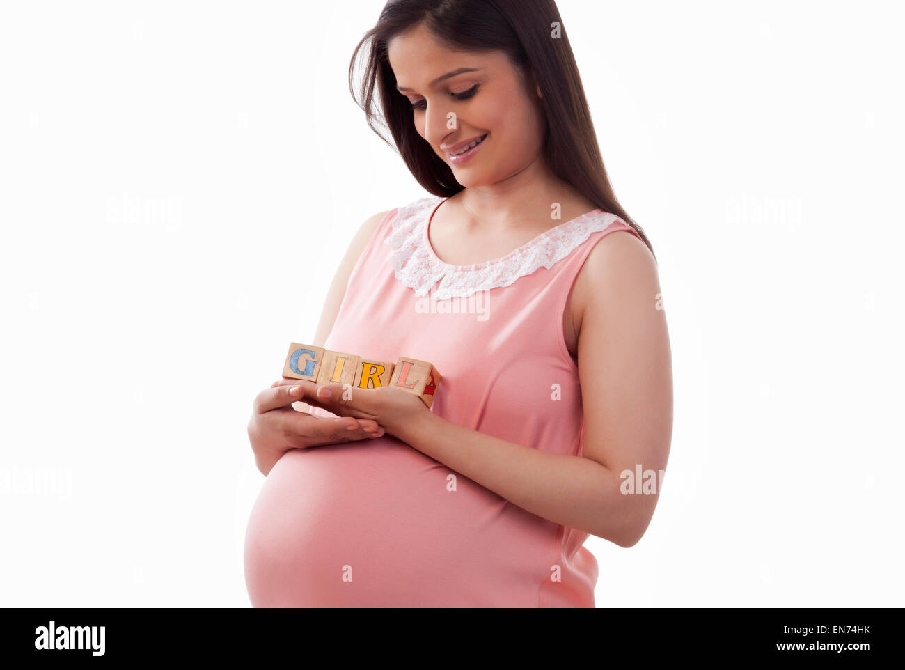 Mujer embarazada la celebración de bloques que deletrear chica Foto de stock