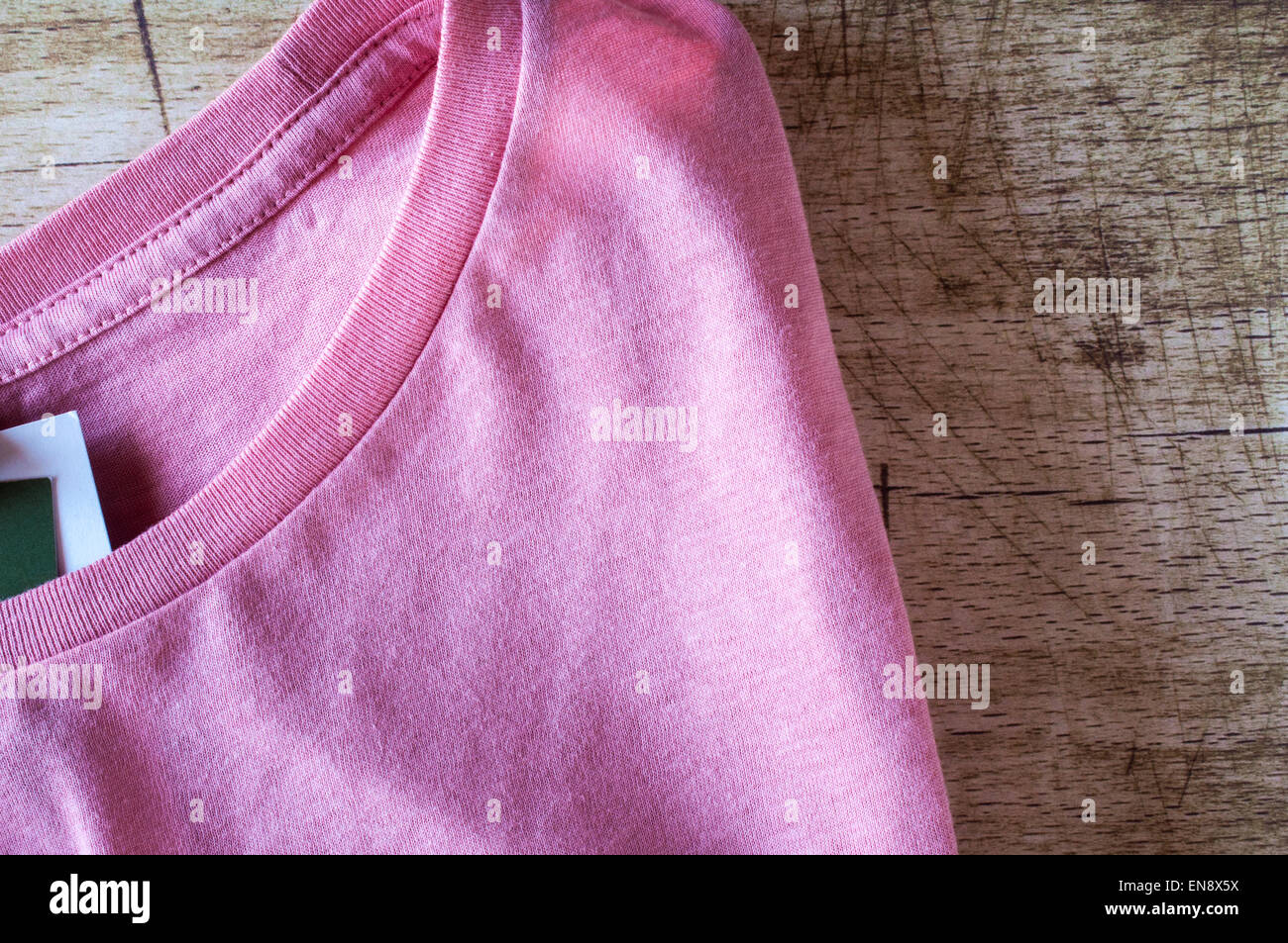 Rosa cuello redondo T-Shirt cerrar sobre fondo de madera Foto de stock