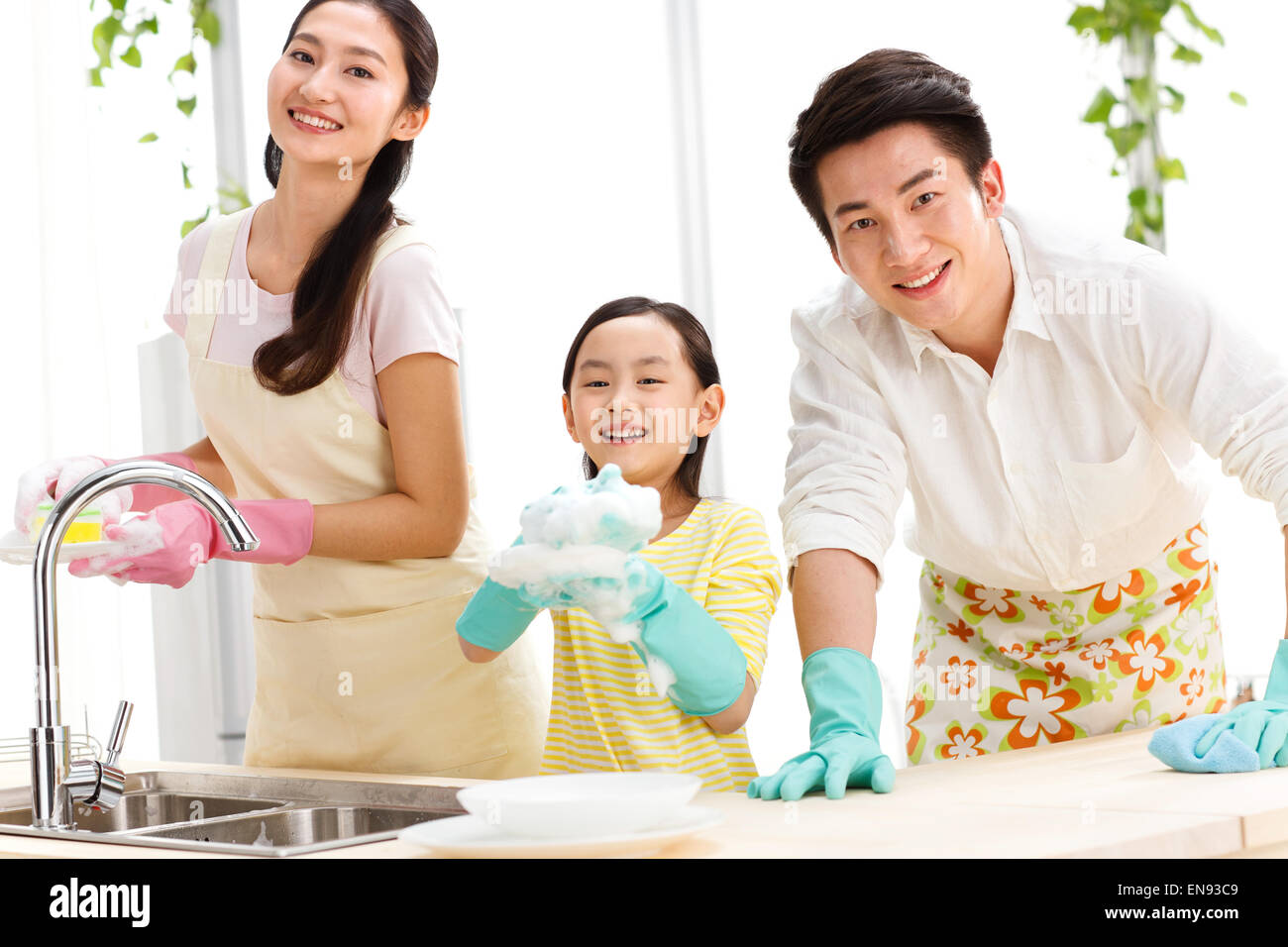 Familia haciendo la limpieza en la cocina Foto de stock