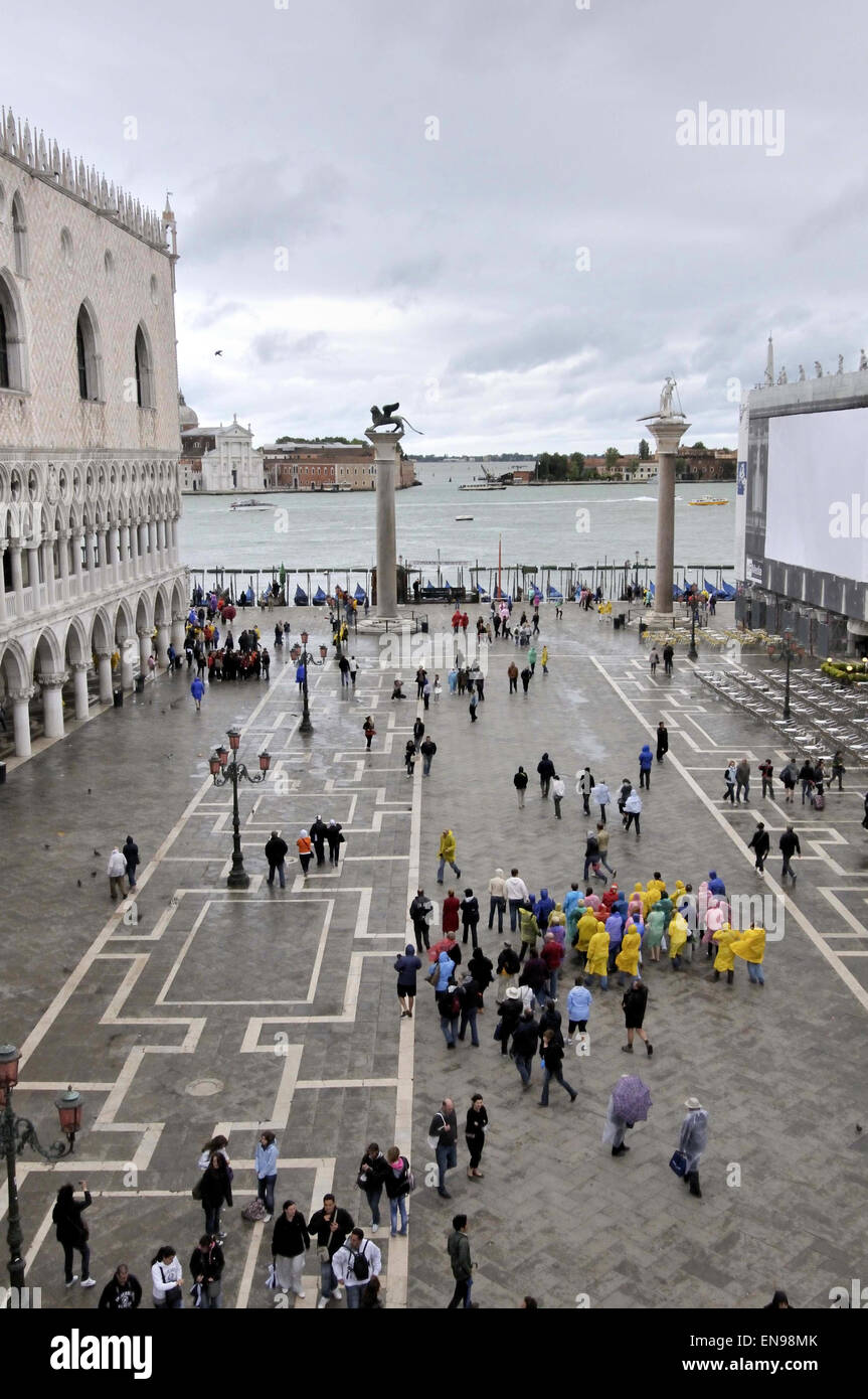 Los turistas con impermeables y paraguas en Piazzetta San Marco por el Palacio Ducal, Venecia, Véneto, Italia Foto de stock
