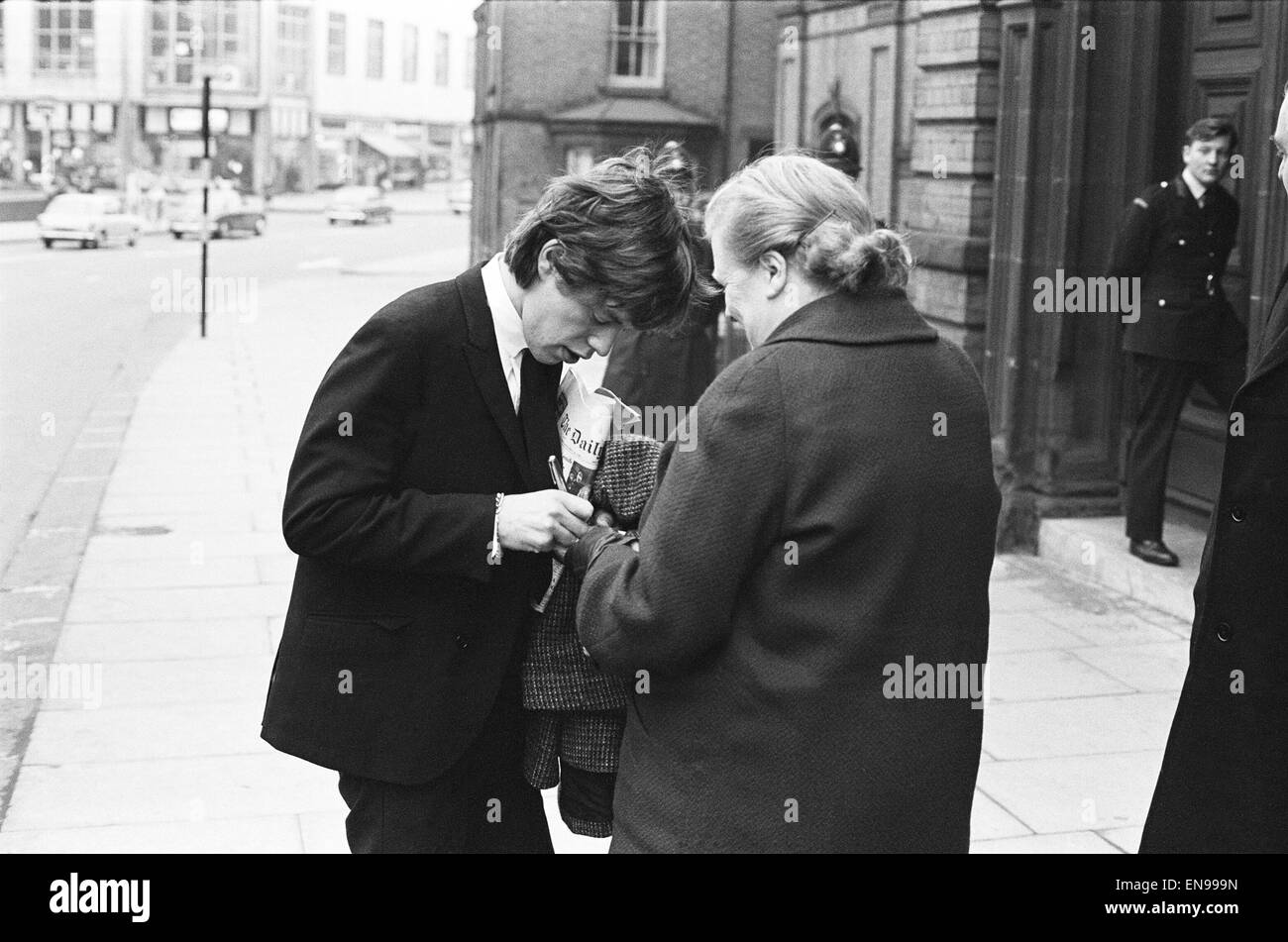 Rolling Stones; Mick Jagger firma un autógrafo fuera del corte en Tattenhall, Staffordshire tras ser declarado culpable de tres delitos de tráfico. El 26 de noviembre de 1964. Foto de stock