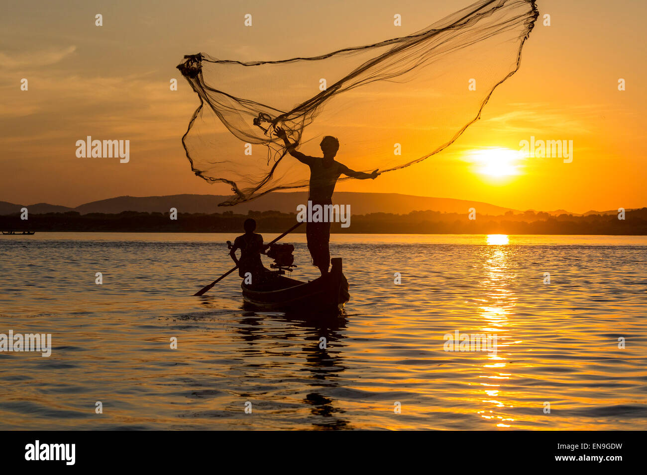 Silueta de pescadores lanzando su red de pesca fotografías e