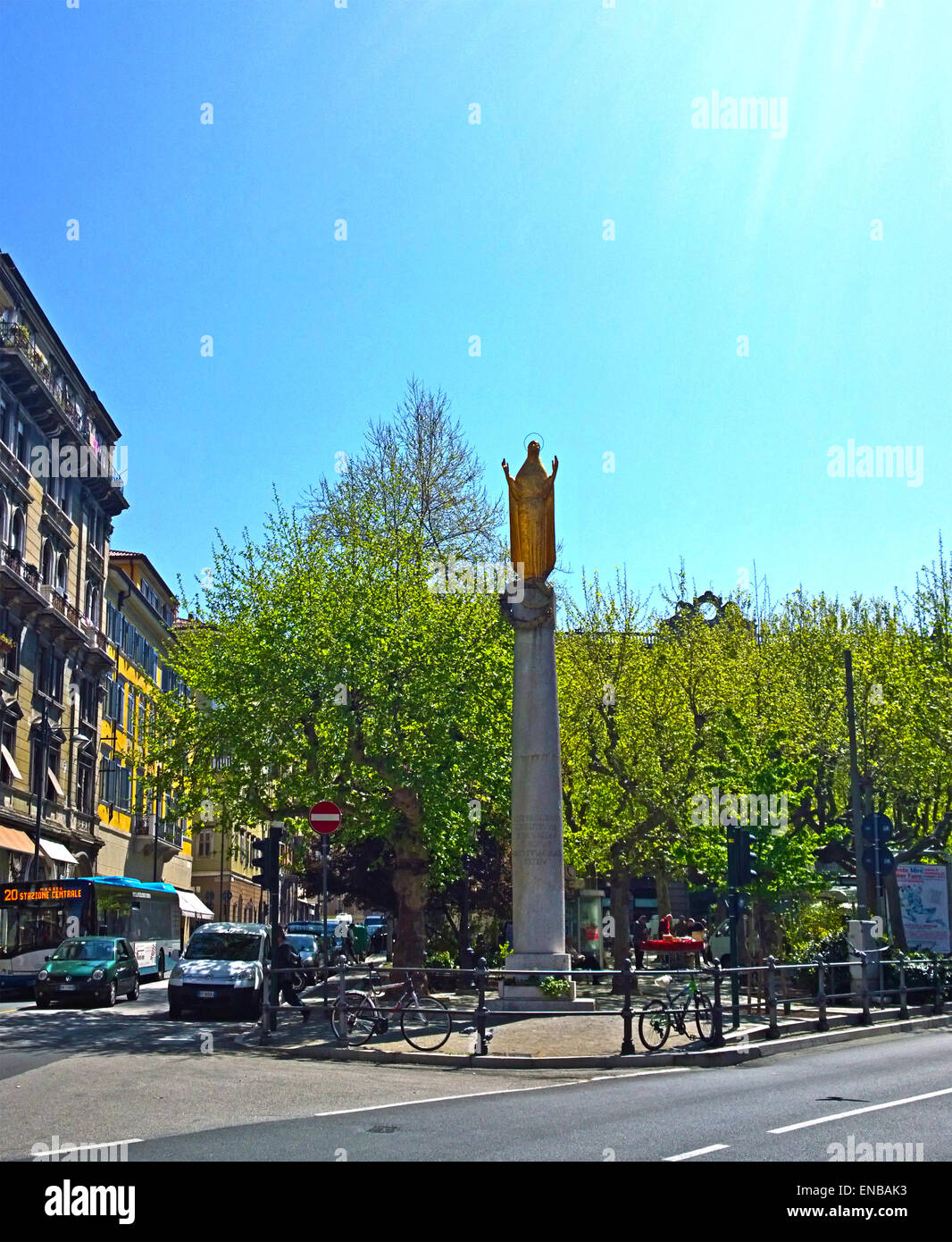Trieste, Italia - Piazza Garibaldi con un pequeño parque en el centro de plaza y golden Madonnina estatua en pilar Foto de stock