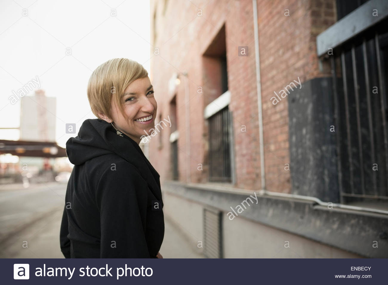 Retrato de mujer rubia sonriendo girando en la calle urbana Foto de stock