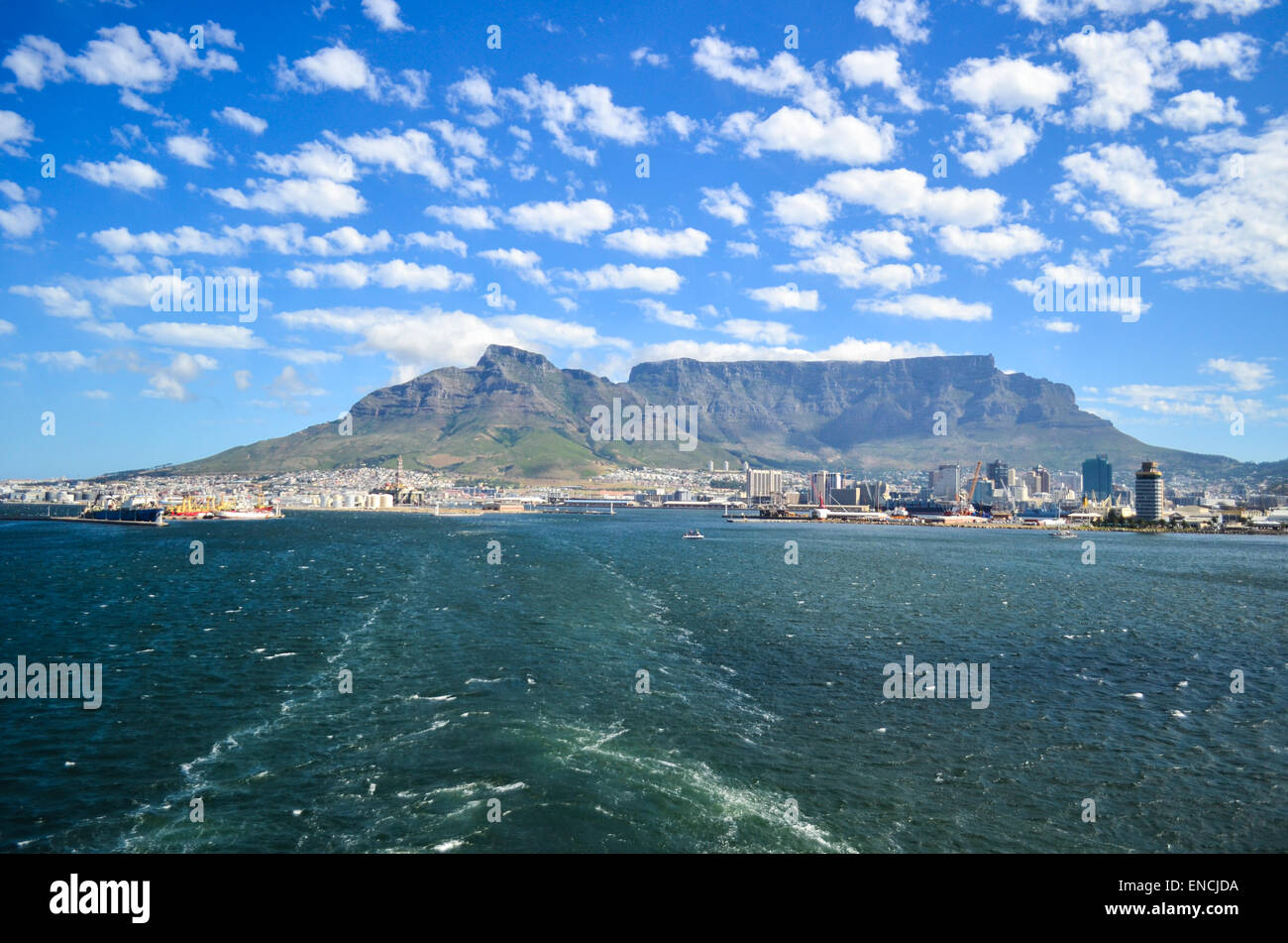 Seguimiento de un buque en el mar, saliendo del puerto de Ciudad del Cabo, Sudáfrica, y la montaña de la Mesa en el fondo Foto de stock