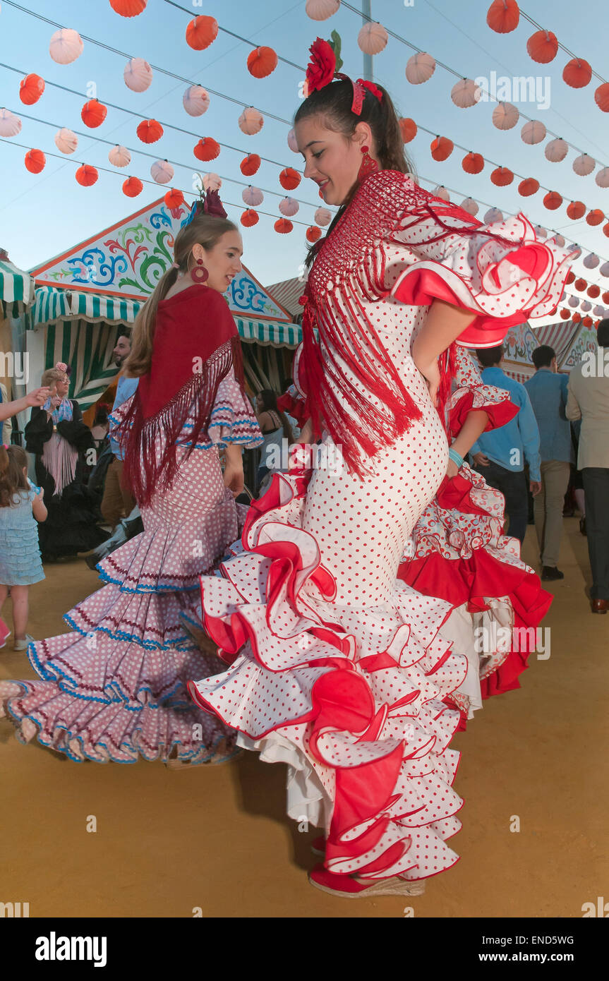 Feria de Abril, las mujeres jóvenes bailando con el tradicional vestido de flamenco, Sevilla, en la región de Andalucía, España, Europa Foto de stock