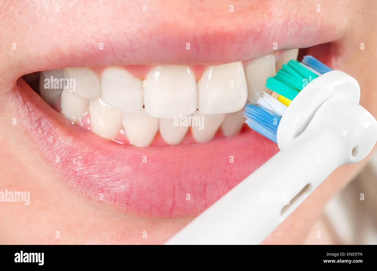 Mujer cepillarse los dientes con el cepillo eléctrico, closeup Foto de stock