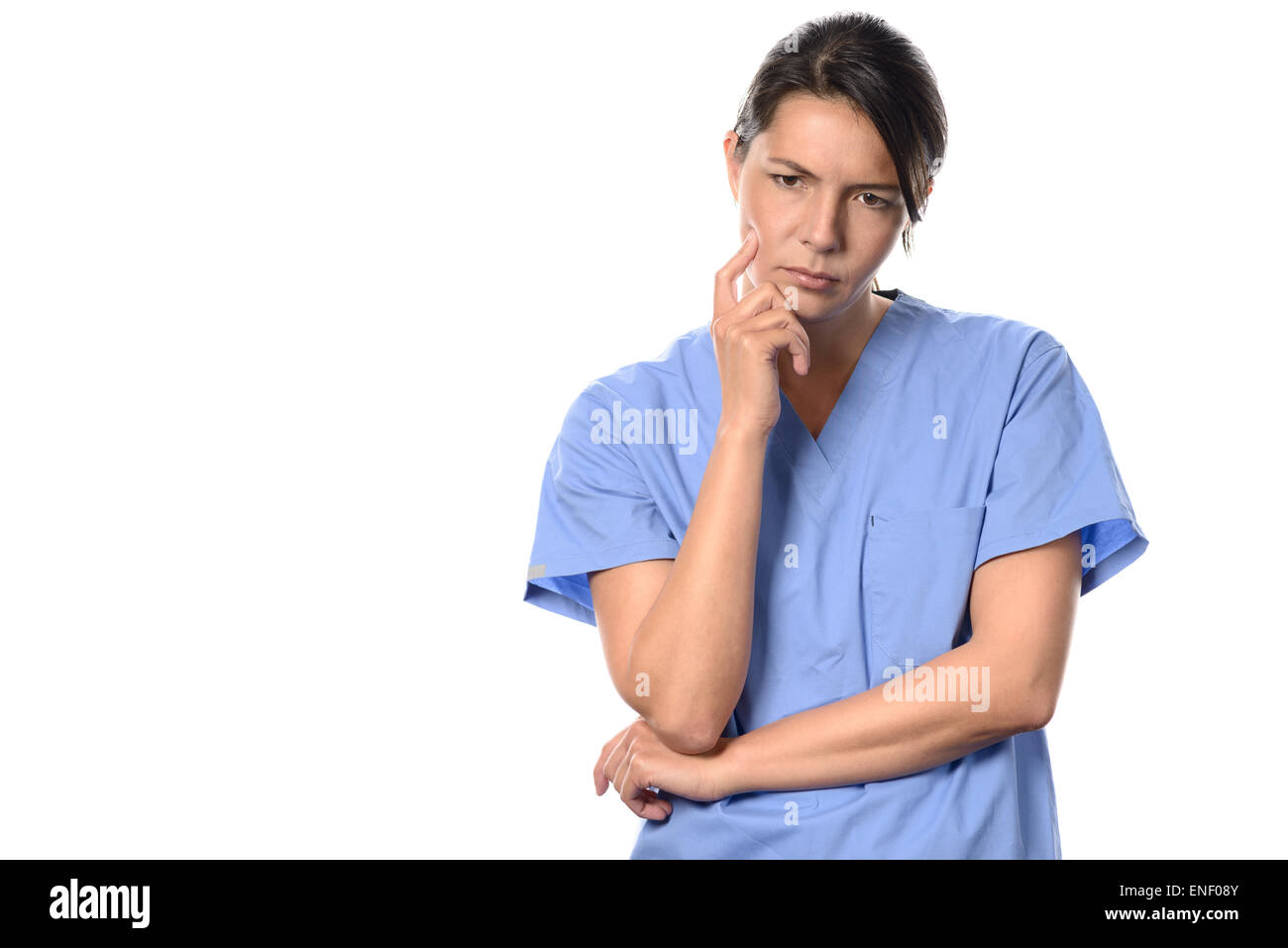 Desanimado joven médico o enfermero vestido de azul scrubs quirúrgica en el piso morosely mira fijamente con una expresión pensativa, es Foto de stock