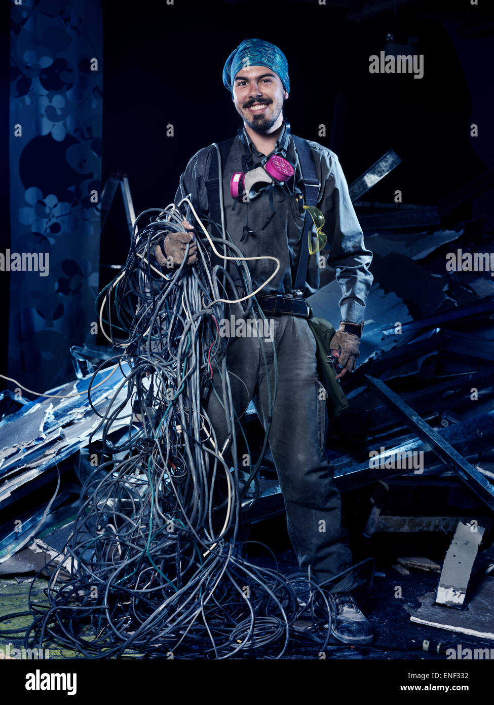 Contratista eléctrica sonriente en el trabajo con un montón de cables retrato artístico Foto de stock