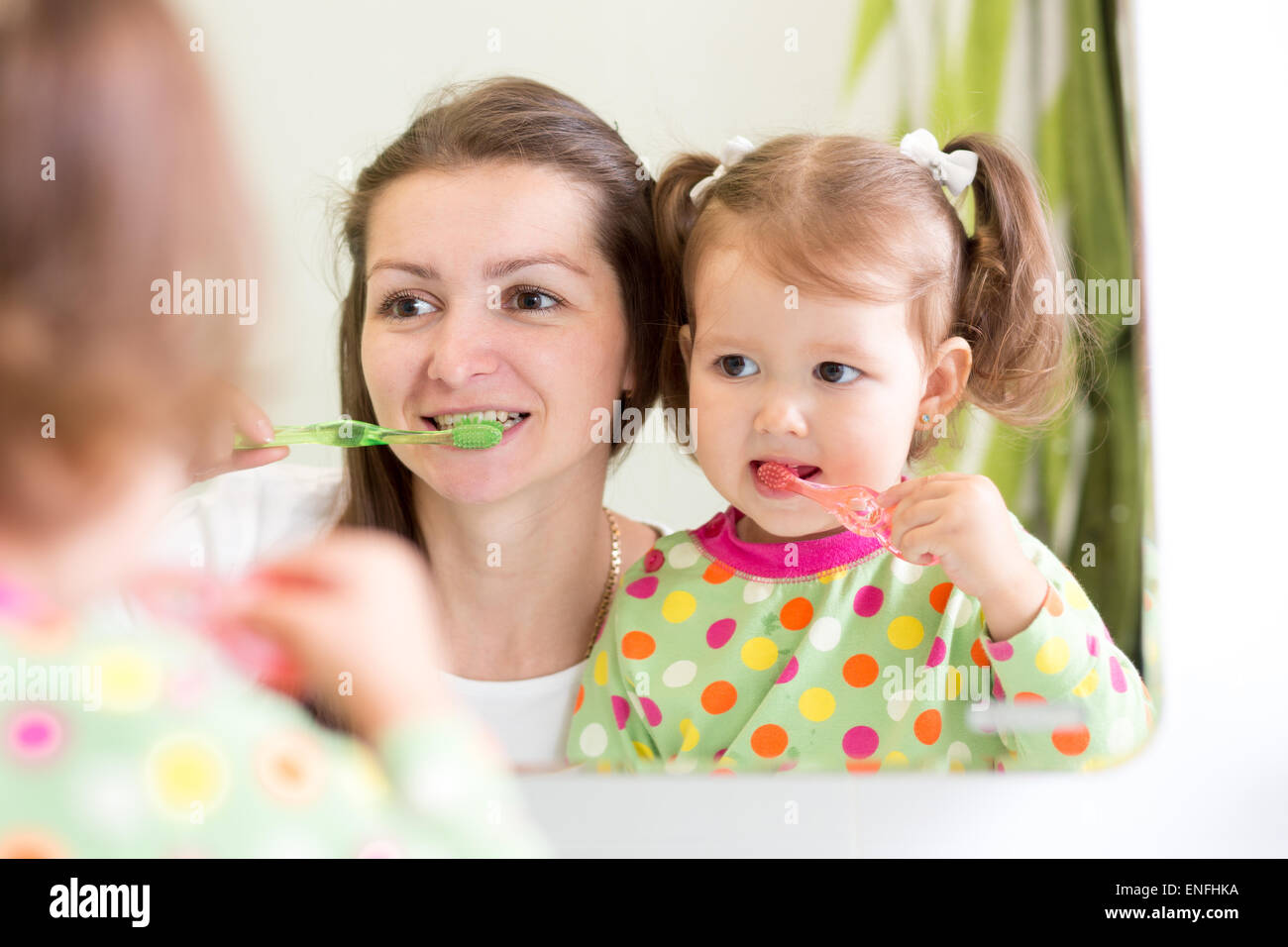 Madre de la enseñanza infantil hija cepillado de dientes en el baño. Foto de stock