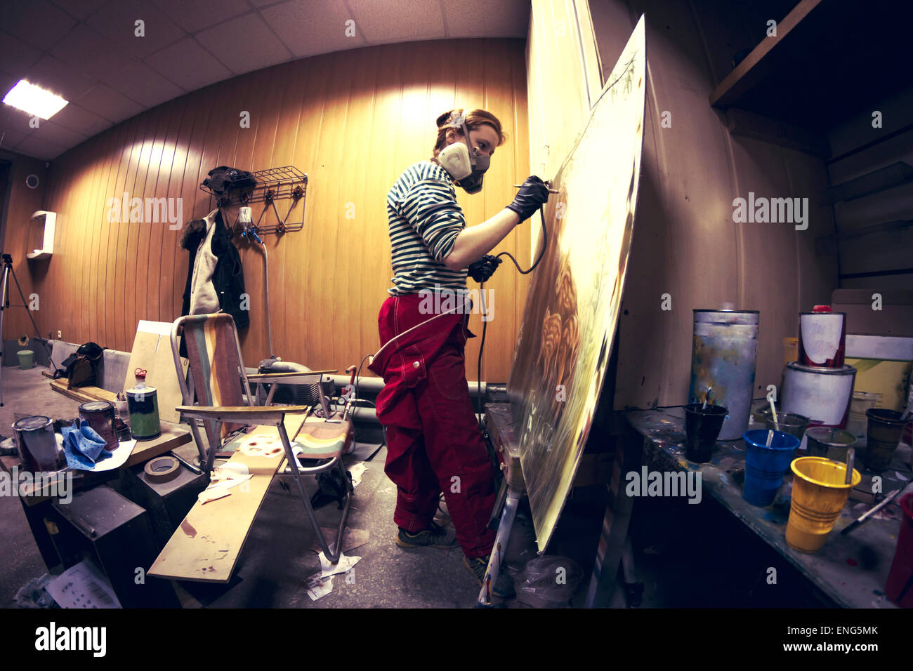 Artista en máscara de gas aerografía pintura en studio Foto de stock