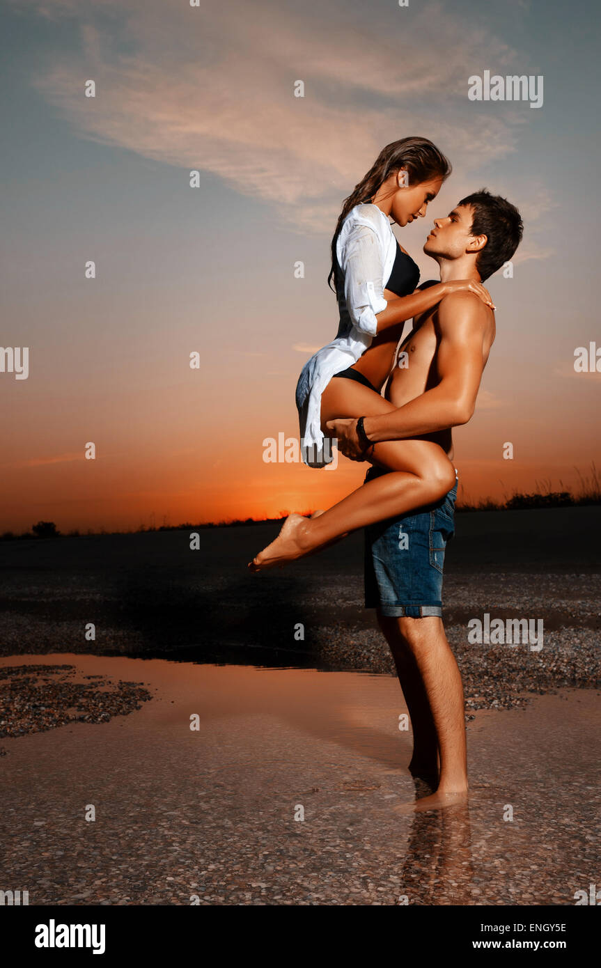 Joven pareja besándose en la playa con el sol detrás de ellos Fotografía de stock - Alamy Joven pareja besándose en la playa con el sol detrás de ellos Fotografía de stock - Alamy