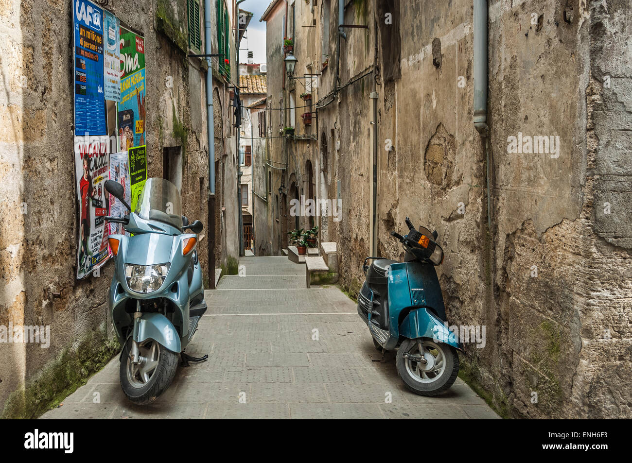 Motos aparcadas en callejones de Pitigliano, Italia Foto de stock