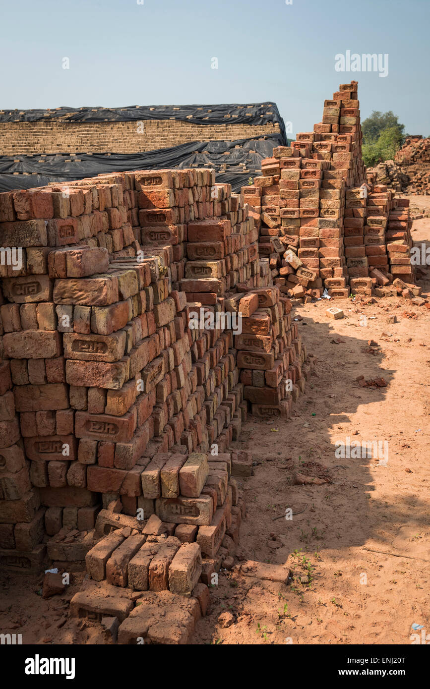 Las pilas de ladrillos recientemente disparados en un ladrillo trabaja en Uttar Pradesh, India Foto de stock