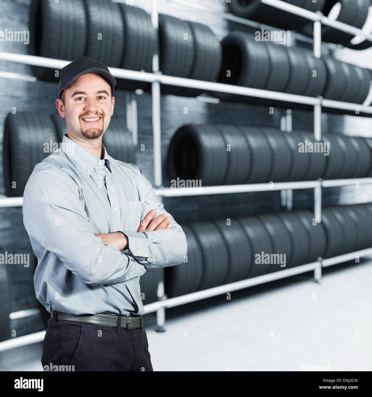 Garaje sonriente hombre y neumáticos antecedentes Foto de stock