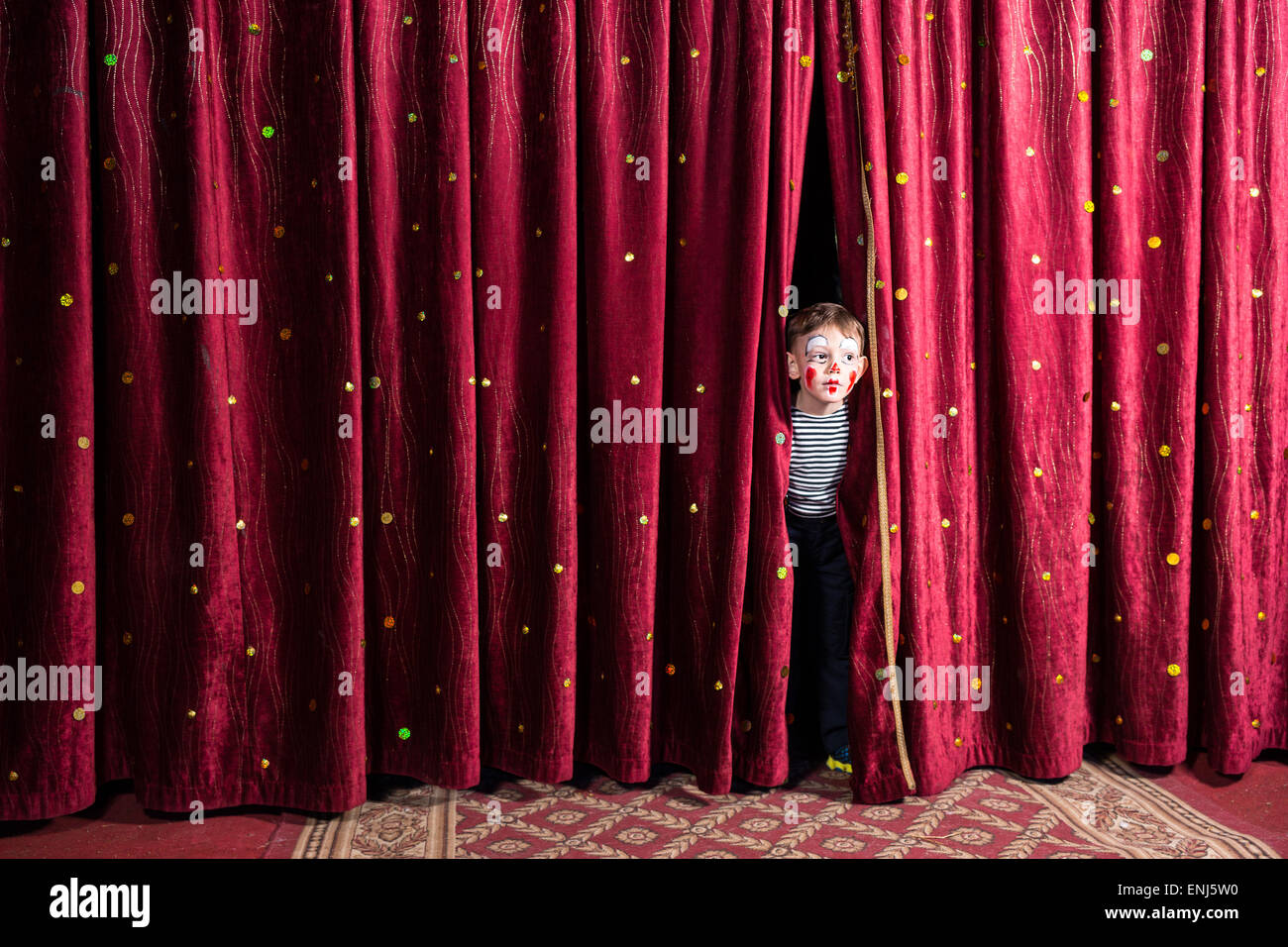 Chico emocionado en el escenario asomándose por entre las cortinas en su vestuario y maquillaje esperando el rendimiento para comenzar Fotografía de stock - Alamy Chico emocionado en el escenario asomándose por entre las cortinas en su vestuario y maquillaje esperando el rendimiento para comenzar Fotografía de stock - Alamy