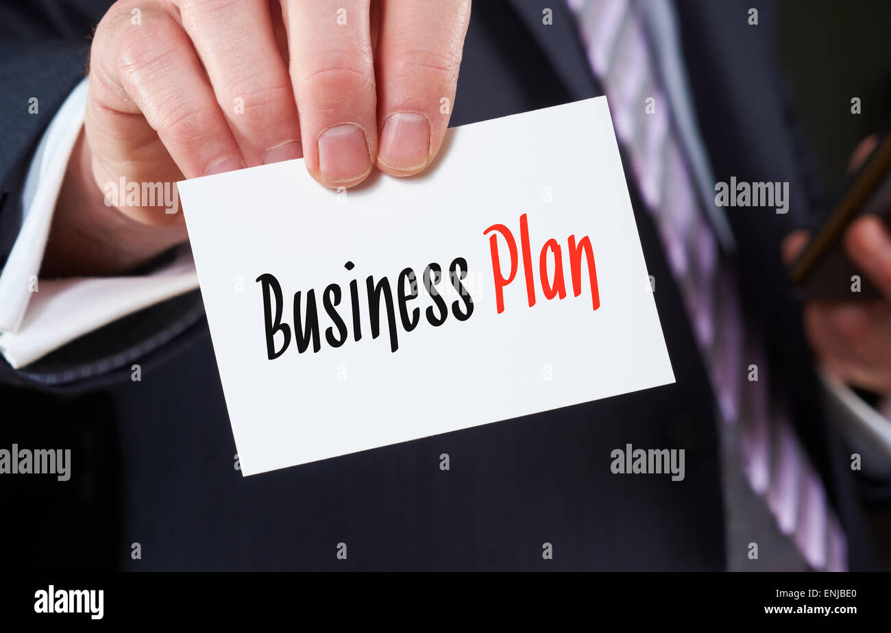 Un empresario sosteniendo una tarjeta con las palabras, Plan de Negocios, escrito en ella. Foto de stock