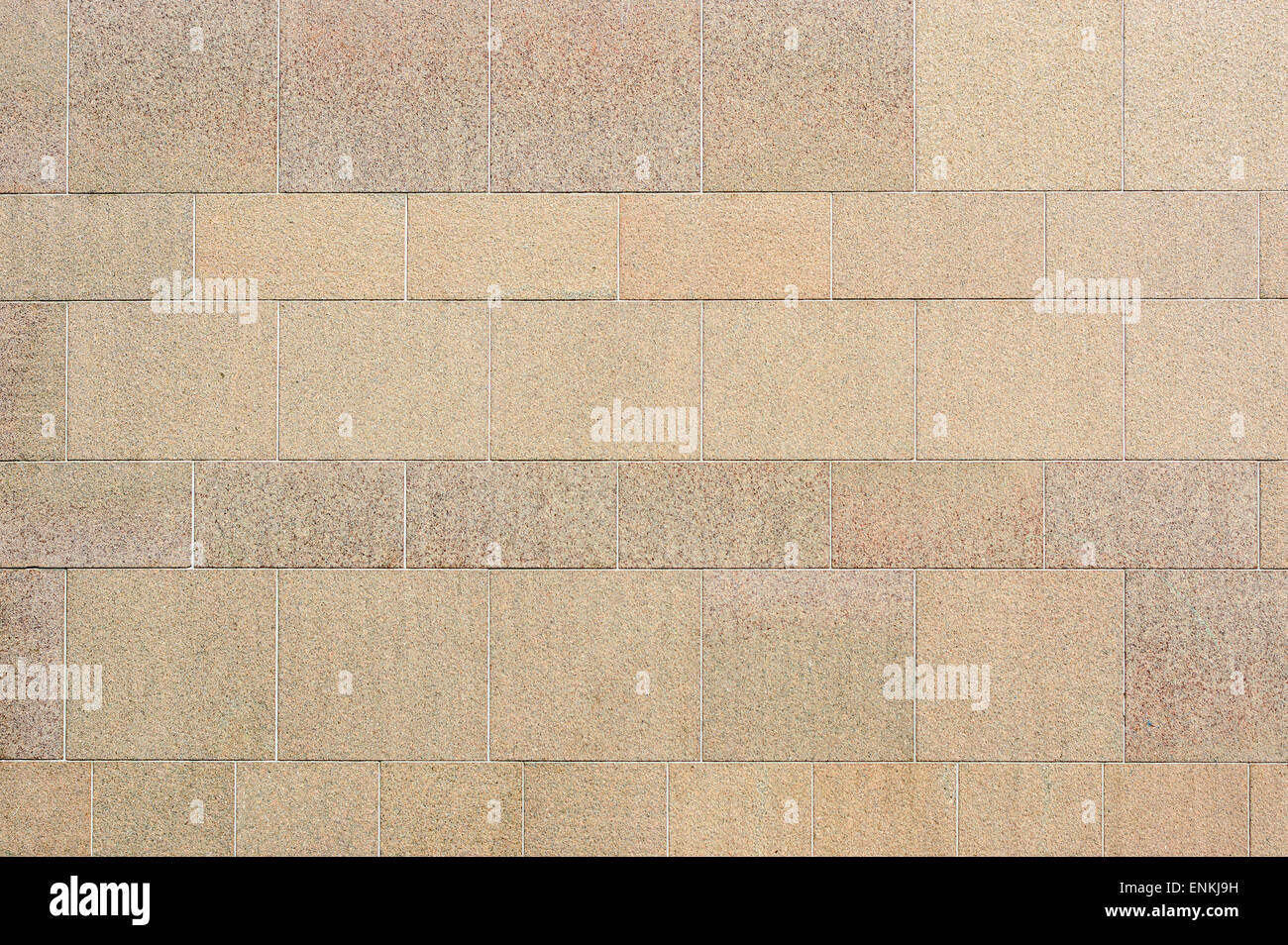 Muro de piedra fina de color beige grisáceo. Los bloques de piedra de distinto tamaño se utilizan para crear el patrón. Foto de stock