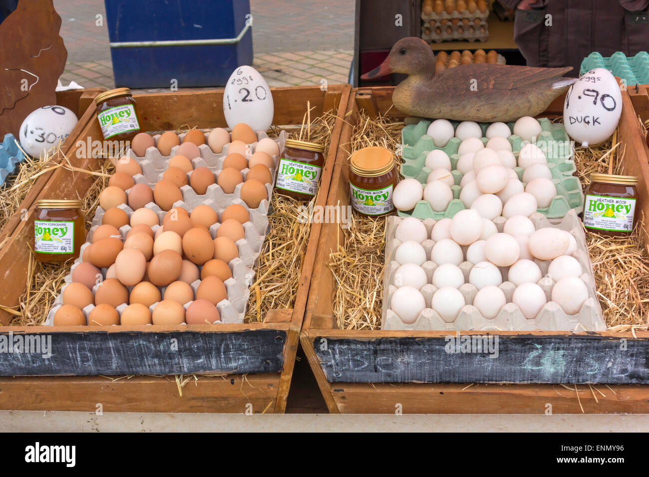 Una pantalla de huevos de gallinas marrón y blanco huevos de pato y miel de brezo sobre un especialista puesto en el mercado del agricultor. Foto de stock