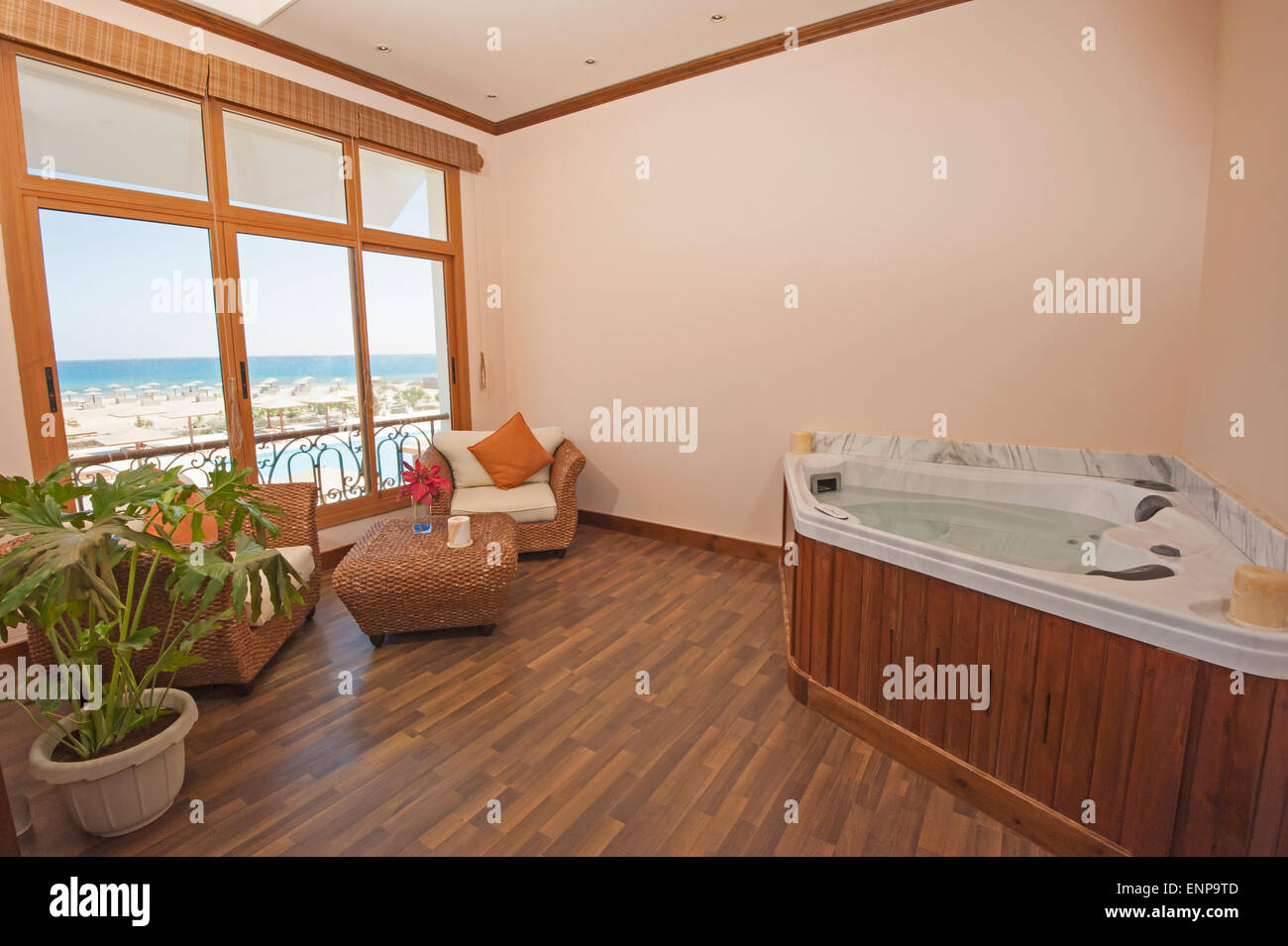 Jacuzzi en la habitación privada de spa de lujo con sillas y vistas al mar Foto de stock