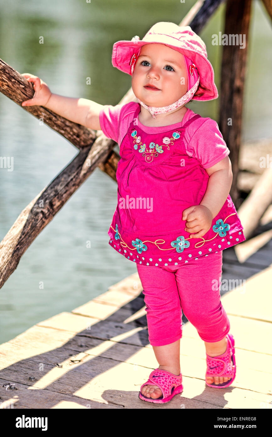 Una bonita niña con sombrero de color rosa divirtiéndose Foto de stock