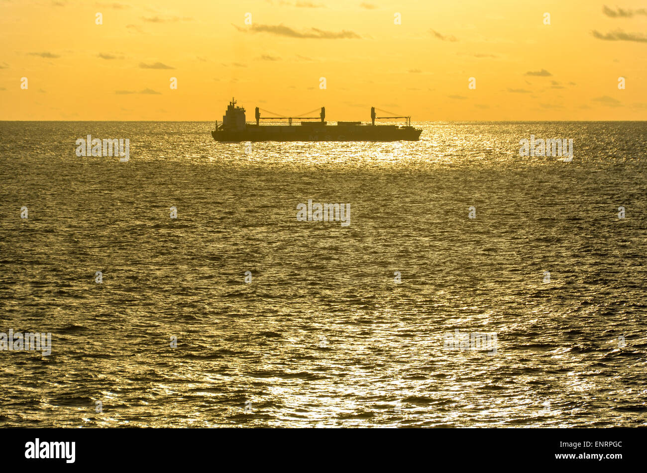 Barco bajo la luz de la puesta de sol en el océano Atlántico Foto de stock