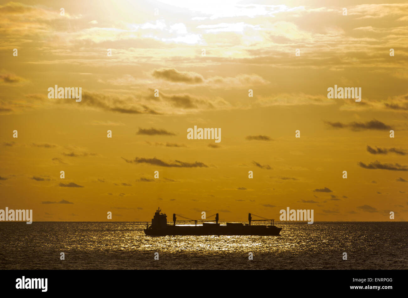 Barco bajo la luz de la puesta de sol en el océano Atlántico Foto de stock