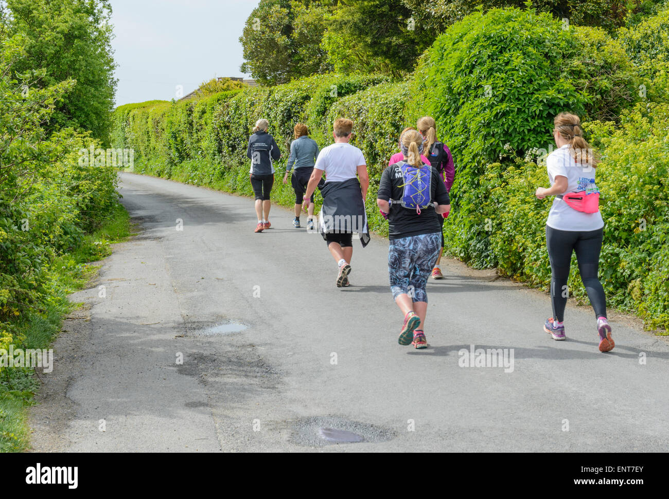 Un pequeño grupo de gente haciendo footing en un país por carretera. Foto de stock