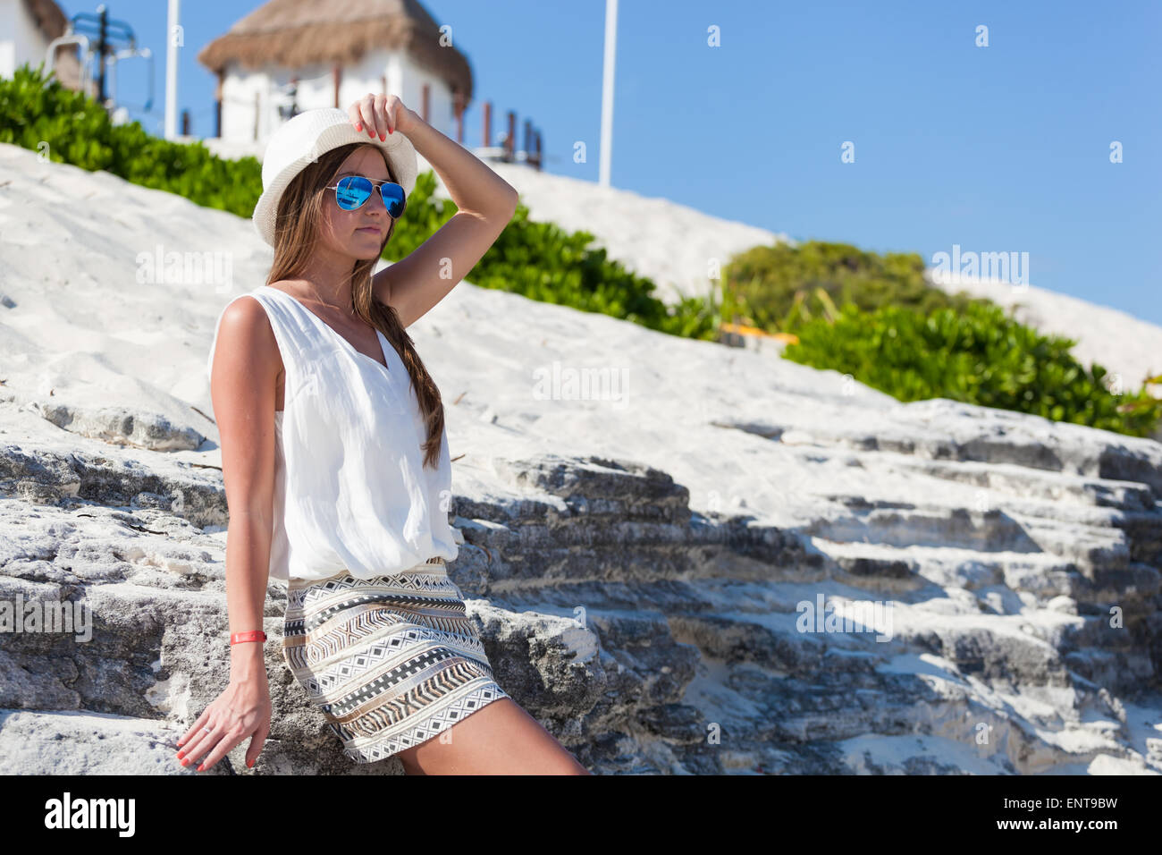 Hermosa mujer bronceada posando antecedentes del rock, disfrutando de las vacaciones de verano Foto de stock