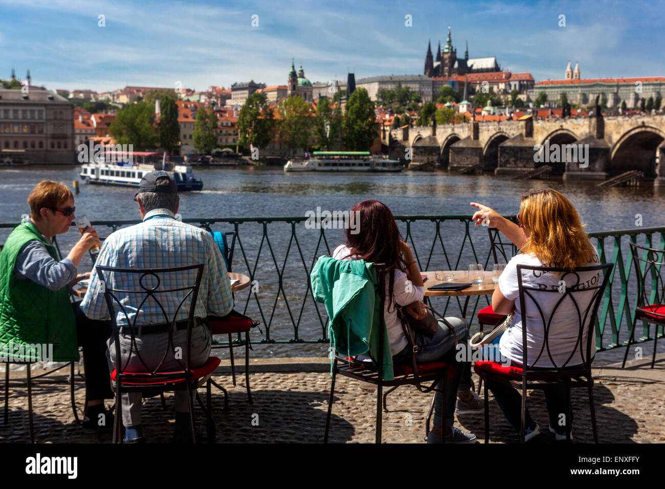Personas en el restaurante de la terraza Novotneho Lavka, vista panorámica de Praga, puente de Carlos Vltava río Vltava en el castillo de Praga, República Checa, verano de Europa Foto de stock