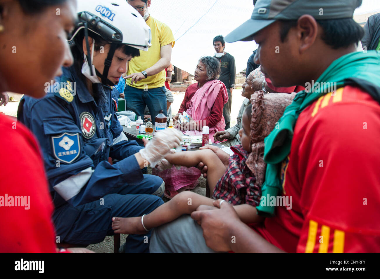 Un médico chino de tratar a un niño afectado por Nepal terremoto en San'khu Village. Ha sido un año y condiciones havent cambiado Foto de stock
