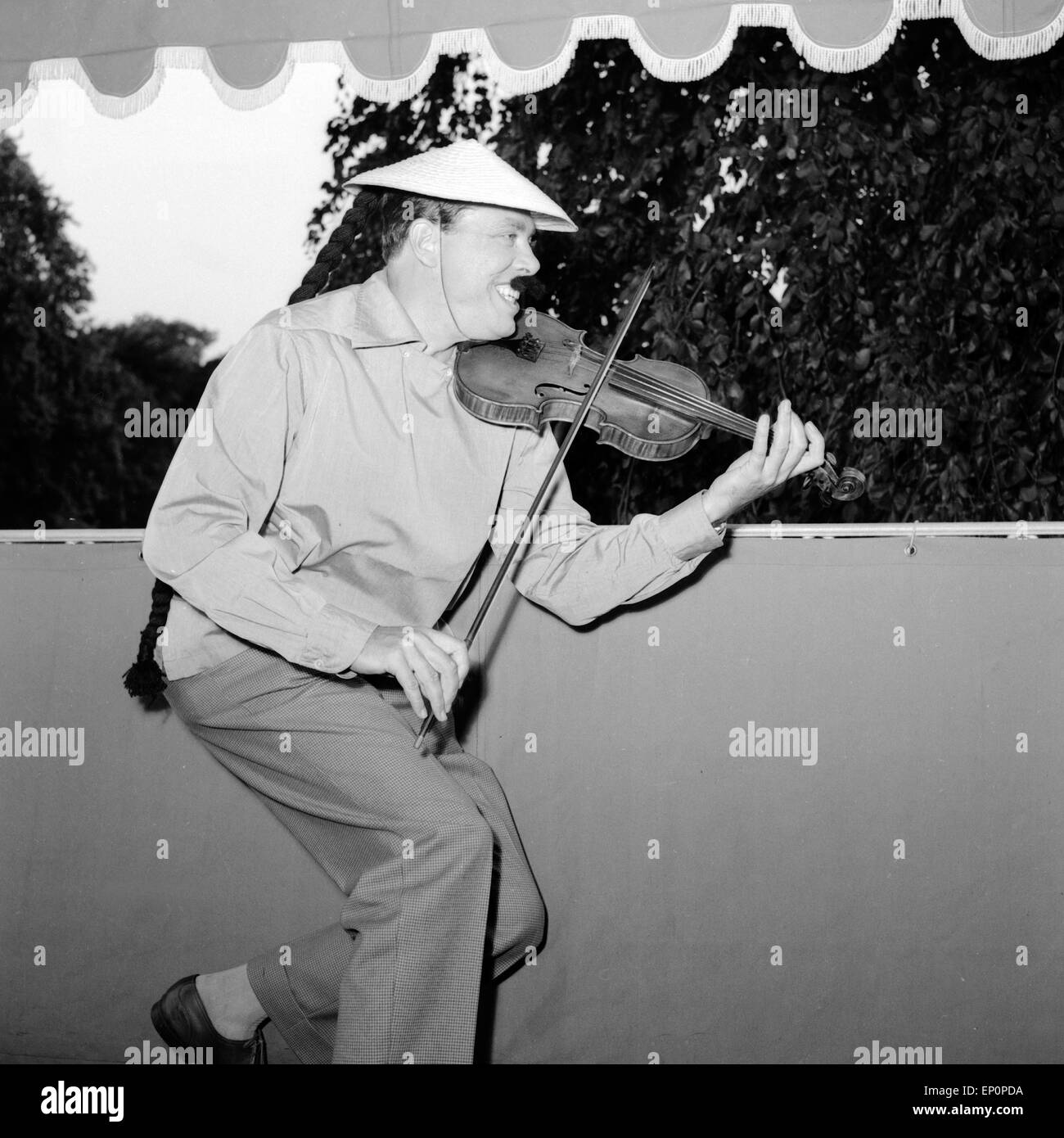 Deutscher violinista Helmut Zacharias spielt auf seinem Geige Balkon en Hamburgo, als verkleidet chino, 1955. Violinis alemán Foto de stock
