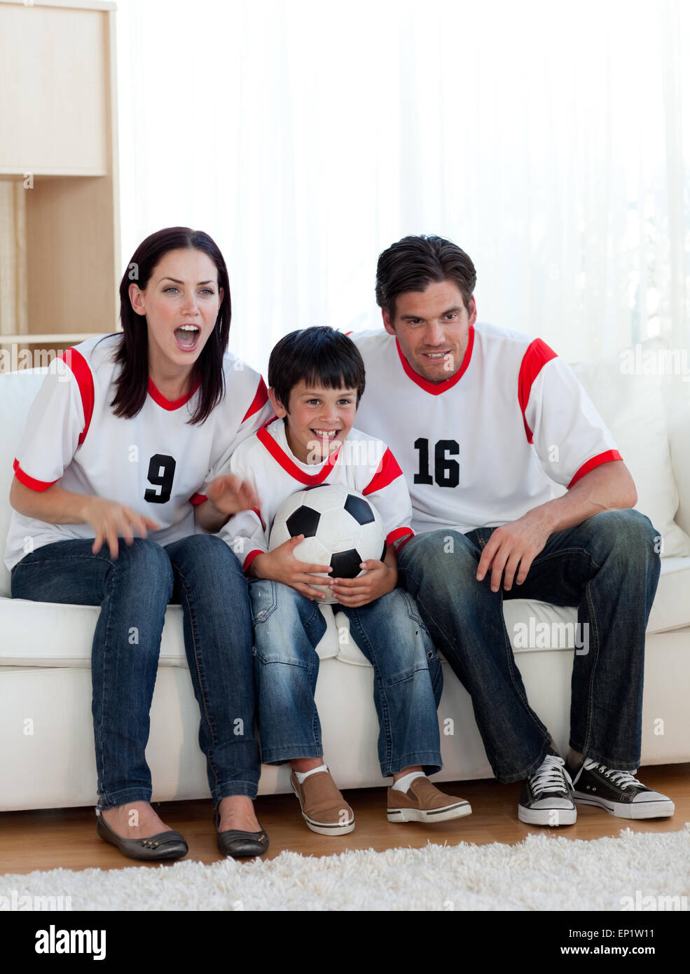 Los padres y su hijo viendo un partido de fútbol Foto de stock