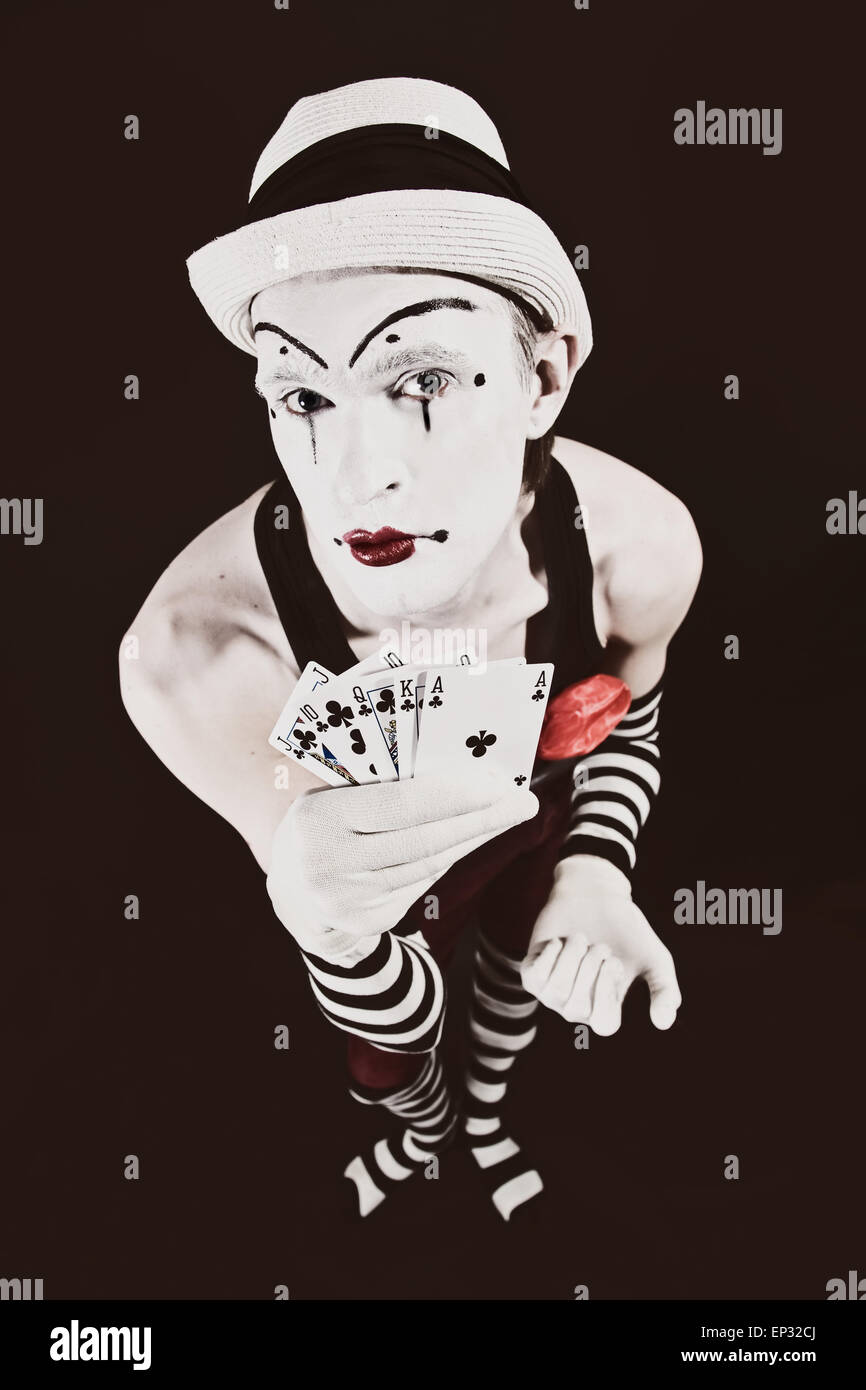 Payaso de circo en el maquillaje con naipes sobre un fondo negro Fotografía  de stock - Alamy