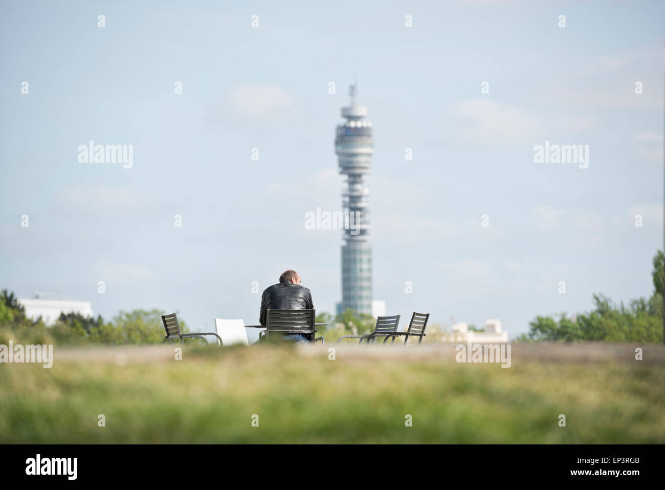 Hombre sentado en su propia con la Torre BT en el fondo Foto de stock