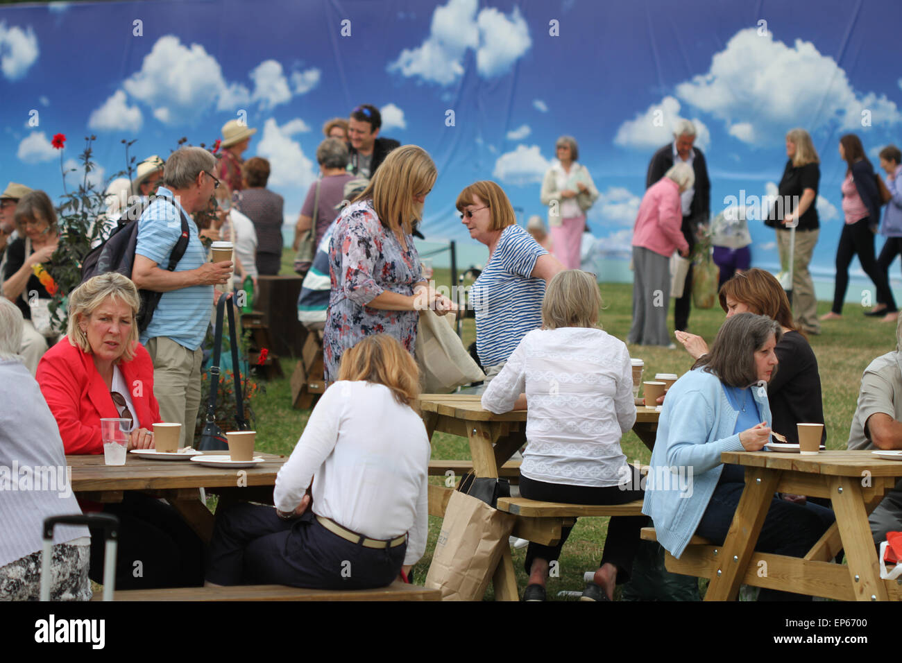 Las personas que toman refrescos en mesas de picnic al lado del turf esculturas en RHS Hampton Court Flower Show, julio de 2014 Foto de stock