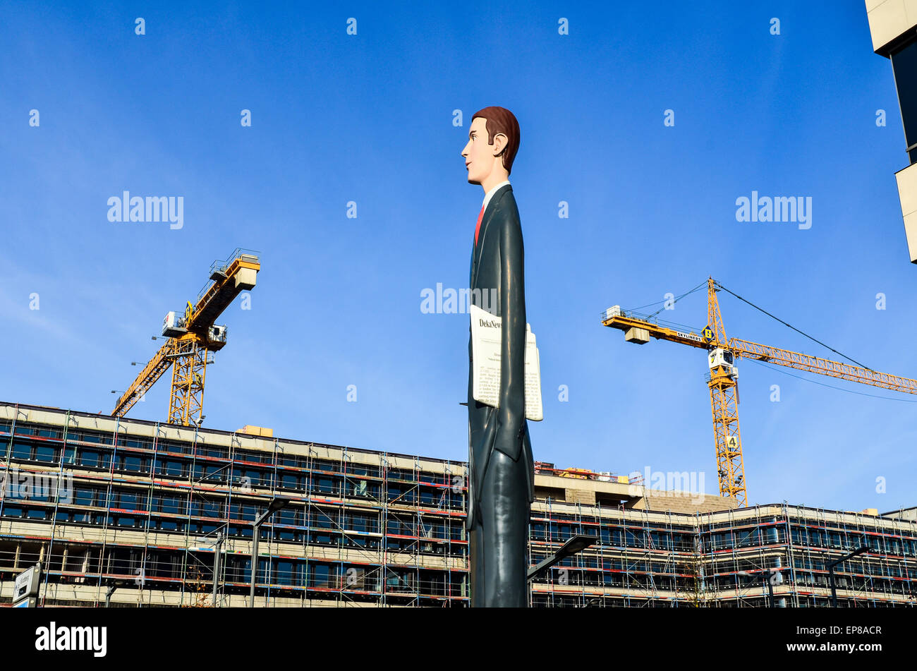Estatua de la "Altura" del banquero en Kirchberg, la ciudad de Luxemburgo, y grúas de construcción en el fondo Foto de stock